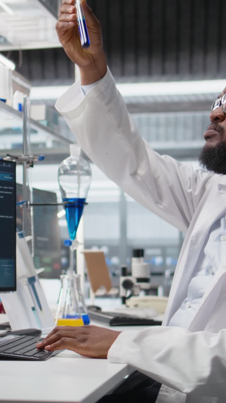 Vertical video Chemical engineer in lab inspecting chemical compounds using PC software
