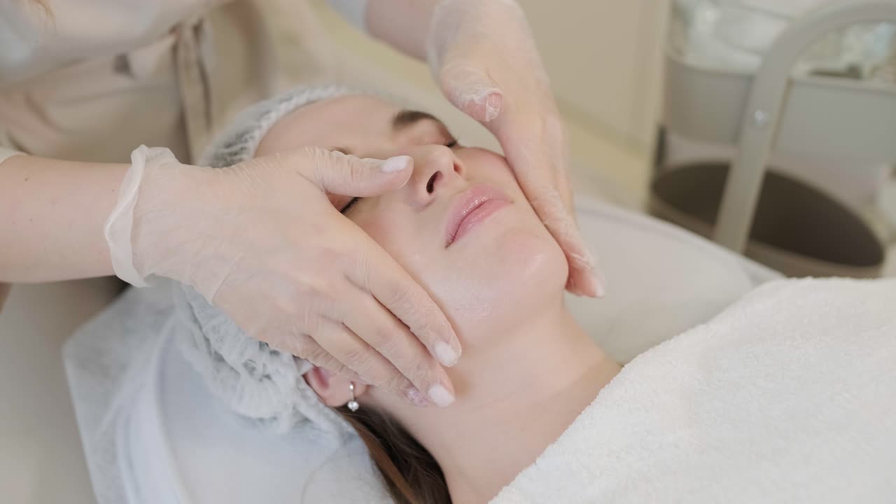 cosmetólogo que hace tratamientos faciales y aplica máscaras faciales