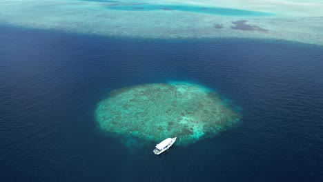 aerial top down to boat moored in little islet of maldives in the proximity of maafushi inhabited islands of kaafu atoll