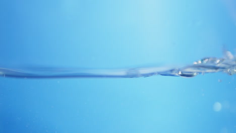 Artistic slow-motion view of water's surface, with striking blue waves representing the essence of purity in clean drinking water.
