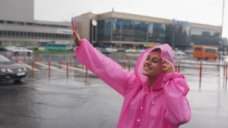 woman in pink raincoat in rainy city