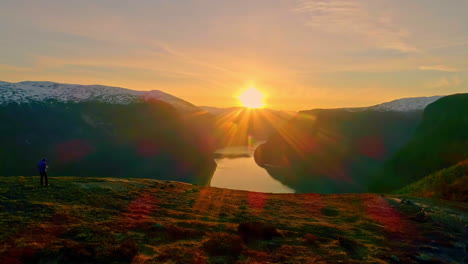 hombre aislado contemplando el increíble paisaje del fiordo al atardecer, noruega