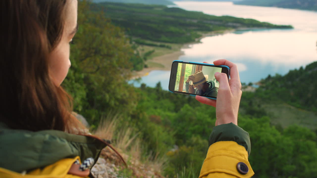 mujer disfrutando de una llamada de video con un amigo en un hermoso entorno natural