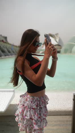 mujer tomando una foto en el parque de la ciudad