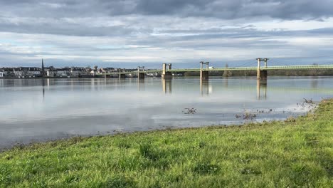 looking across a flooded river loire towards ingrandes le fresne sur loire with bridge