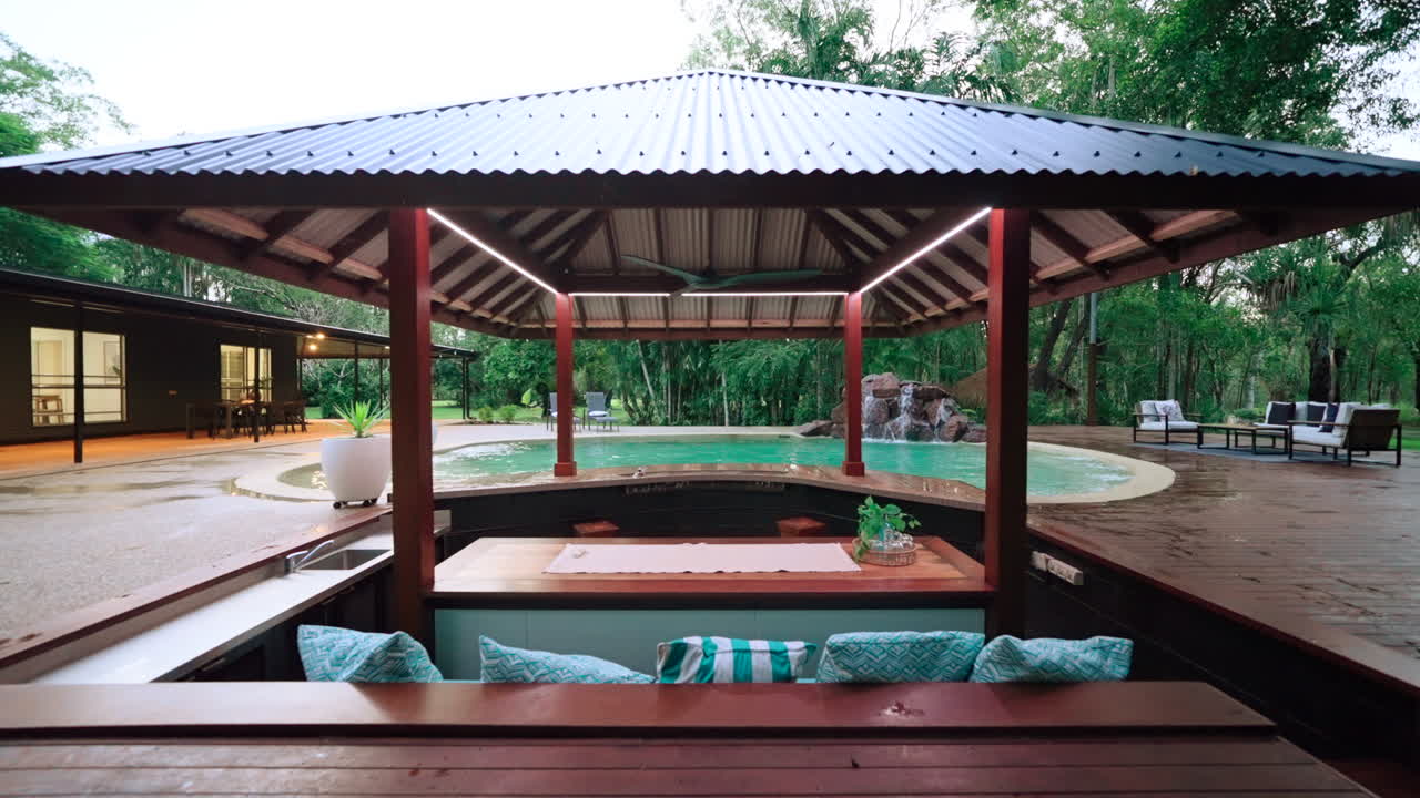 bar de piscina tropical residencial con asientos encajados en una escapada de lujo