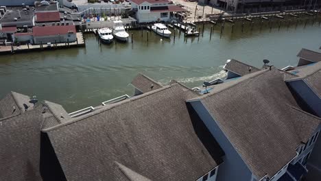 Flying-Over-Upscale-Condos-and-Boat-in-Fishing-Creek,-Chesapeake-Beach-Bay,-Maryland-USA,-Aerial-View-on-Summer-Day