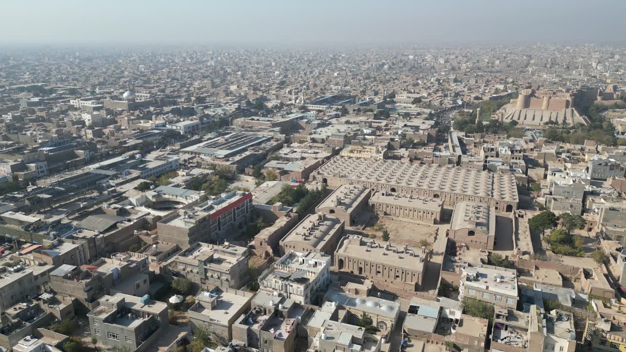 Aerial establishing drone fly above Herat city in Afghanistan, mosque citadel university and town streets