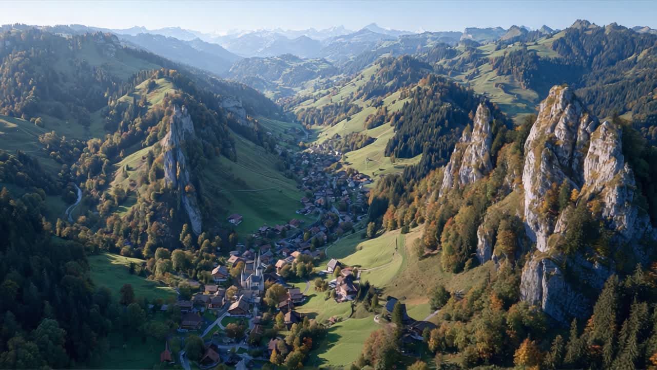 Atemberaubende Luftaufnahme eines malerischen Tals, eingebettet zwischen majestätischen Bergen, das üppiges Grün und malerisches Dorfleben im Herbst zeigt.