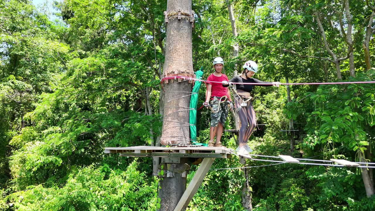 Couple enjoying a treetop adventure course