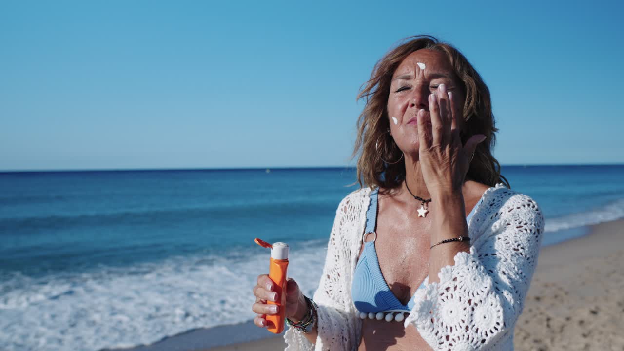 해변 에서 자외선 차단제 를 적용 하는 여자