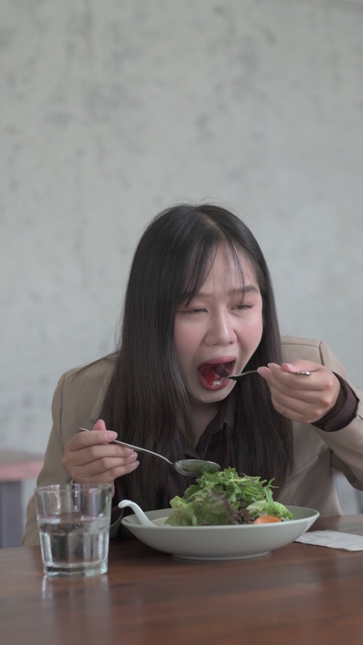 Wanita bahagia makan salad hijau sehat untuk makan siang.