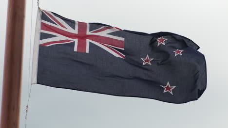 bandera de nueva zelanda ondeando en un día ventoso en queenstown