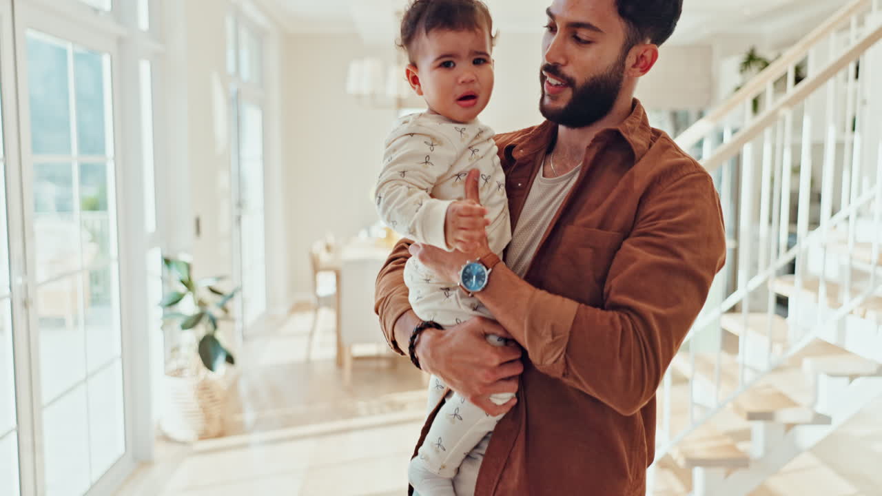 Un padre amorevole che tiene in braccio il suo bambino in una casa luminosa e moderna.