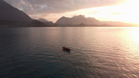 Aufschlussreiche-Luftaufnahme,-Die-Bei-Sonnenuntergang-Langsam-über-Einem-Ruderboot-Kreist