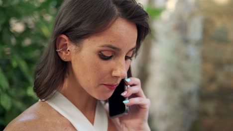 calm woman speaking on cellphone in park