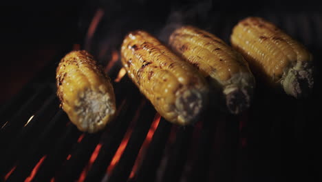 las mazorcas de maíz se tostan en una parrilla sobre carbón caliente