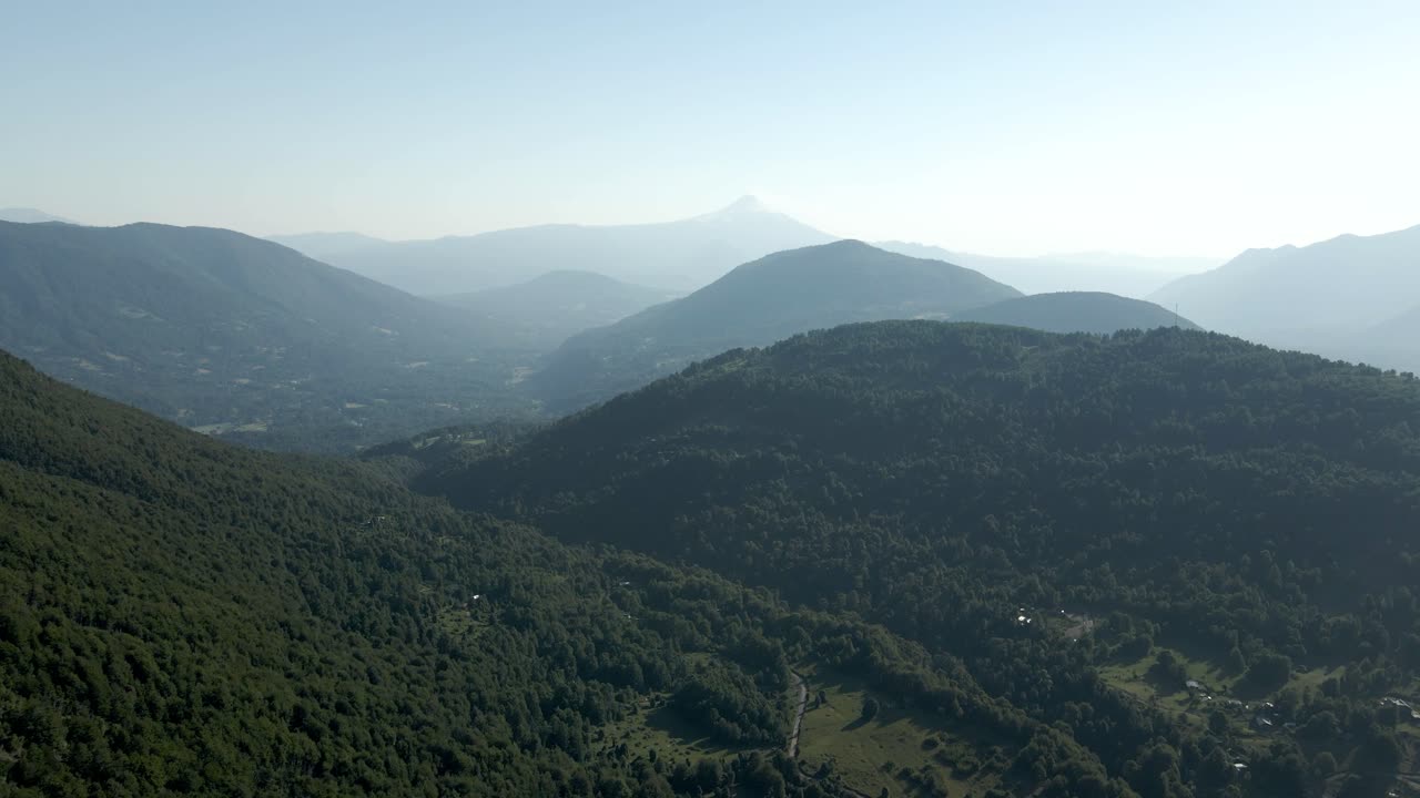 vista panorámica de las montañas en el sur de chile con el volcán villarrica al fondo en un día soleado - antena
