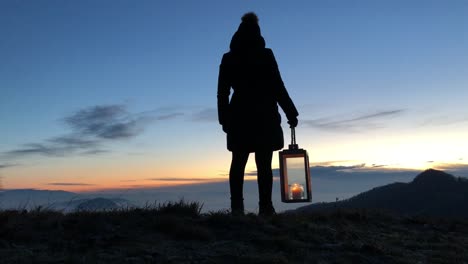 a woman is walking with a lantern, early in the morning