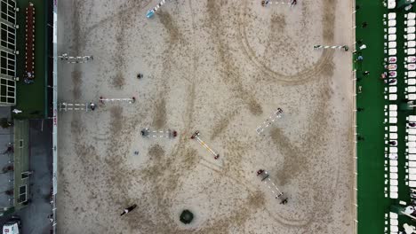 overhead view of equestrians jumping on obstacle course during show jumping tournament in jeddah