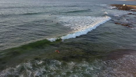 Vista-Aérea-De-La-Ola-De-Trituración-De-Surfistas-En-La-Playa-De-Mereweather,-Australia