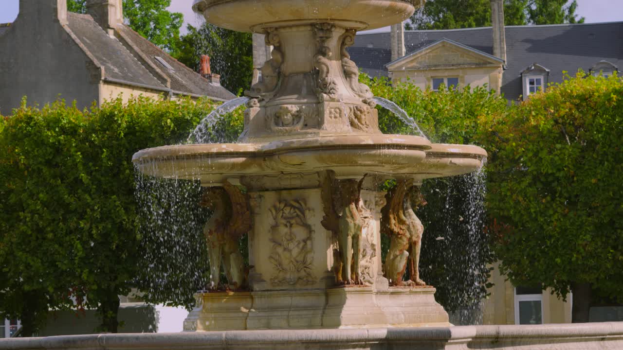 Slow Motion Water Flowing from Stone Fountain on Hot Summer Day with Old Buildings in Background 4K