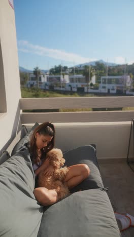 woman and dog relaxing on balcony