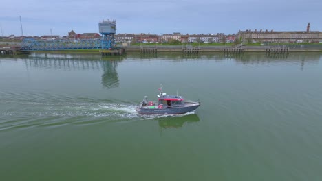 buque de reconocimiento que viaja por un río tranquilo hacia el mar