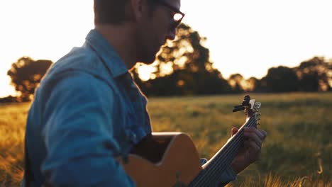 musician playing guitar in field