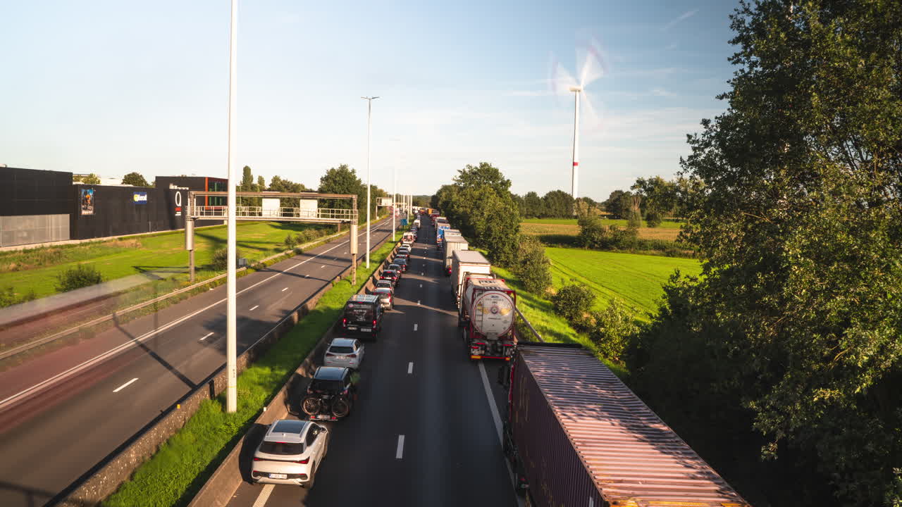 atasco de tráfico y molino de viento en un día soleado en la autopista de bélgica, lapso de tiempo