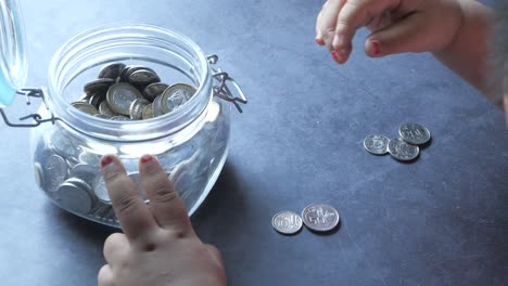 child saving money in a glass jar