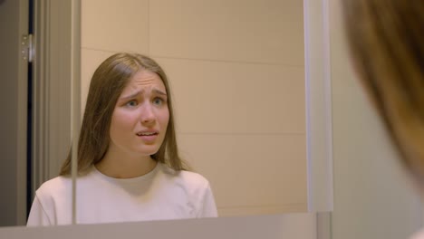 young woman practice speech and acting against mirror, close up view