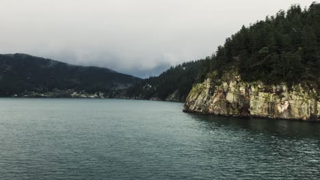 Isla-Gris-Rocosa-Cubierta-De-árboles-Verdes-En-El-Canal-Trincomali-En-Un-Día-Nublado-Y-Lluvioso-En-Canadá