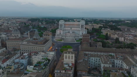 Aerial-slide-and-pan-footage-of-Victor-Emmanuel-II-Monument-and-surrounding-historic-landmarks-at-twilight.-Rome,-Italy