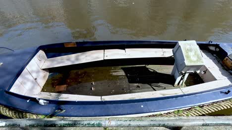 barco de madera vacío y descuidado amarrado al lado del canal