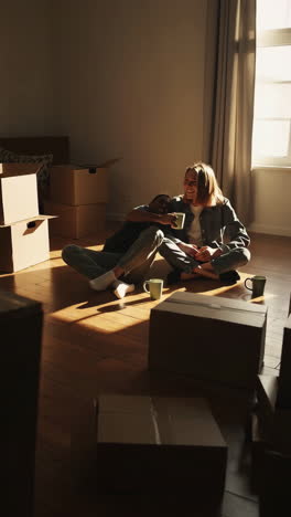 happy couple taking a break on the floor amidst moving boxes in their new home