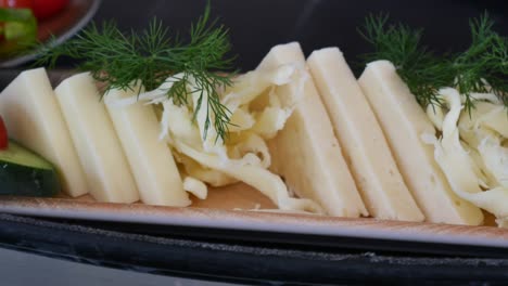 close-up of sliced white cheese with dill