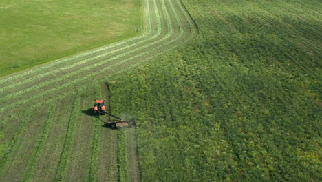 Hacer-Heno-Con-Un-Tractor-Durante-El-Día-En-Saskatchewan,-Canadá---Toma-Aérea