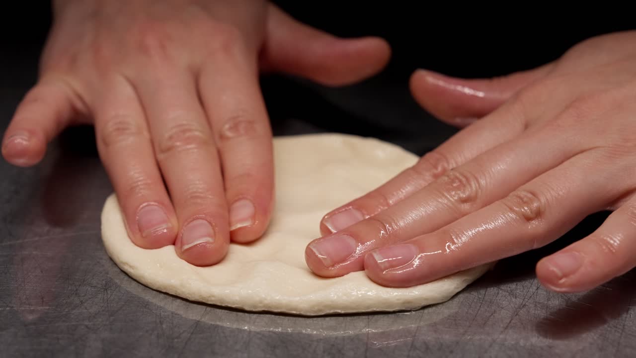 Close-up of Hands Flattening Raw Dough for Baking