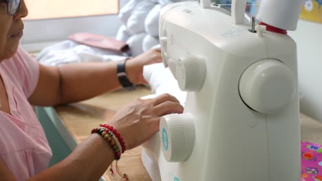 Indigenous-adult-lady-professionally-using-sewing-machine-to-make-therapeutic-neck-pillow