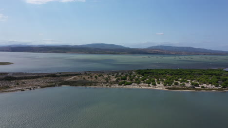 Paisaje-Aéreo-De-Granja-De-Ostras-De-Leucate-Con-Lago-Y-Montañas-Francia-Aude