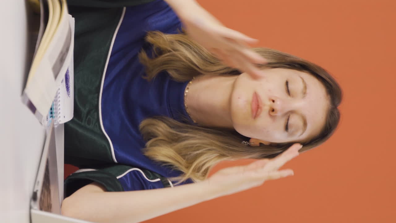 노트북에서 일하는 젊은 여성의 수직 비디오가 두통을  ⁇ 고 있습니다.