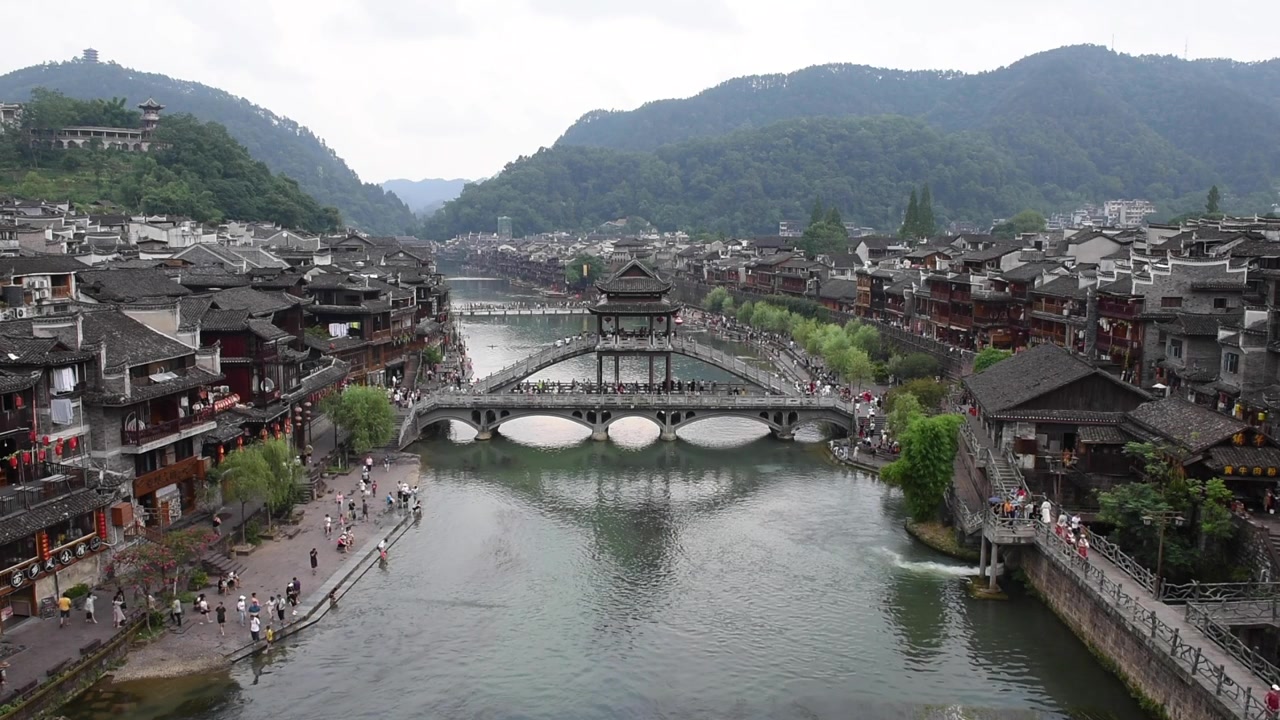 Com vista para a Cidade Antiga de Fenghuang, na Província de Hunan, China, esta vista deslumbrante destaca o encanto histórico da cidade com arquitetura chinesa tradicional, casas sobre palafitas e ruas de paralelepípedos.