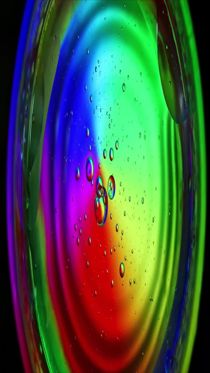 Lebendige Ölblasen schweben in Flüssigkeit mit Regenbogenfarben