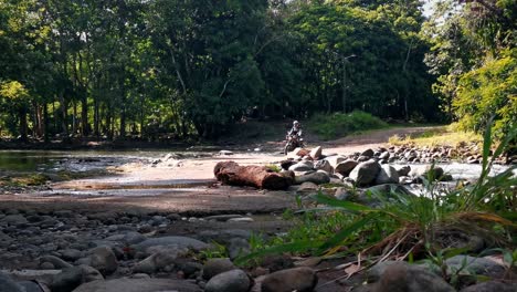 Person-Auf-Einem-Alten-Motorrad,-Das-An-Einem-Sonnigen-Tag-In-Costa-Rica-Einen-Fluss-Mit-Niedrigem-Wasserstand-überquert