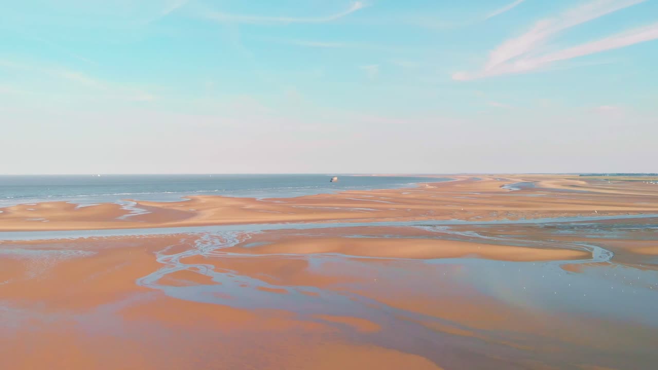 Drone video capturing the serene beauty of Holkham Beach at sunset. Stunning aerial footage showcases expansive sand formations under warm evening light, creating a tranquil coastal panorama