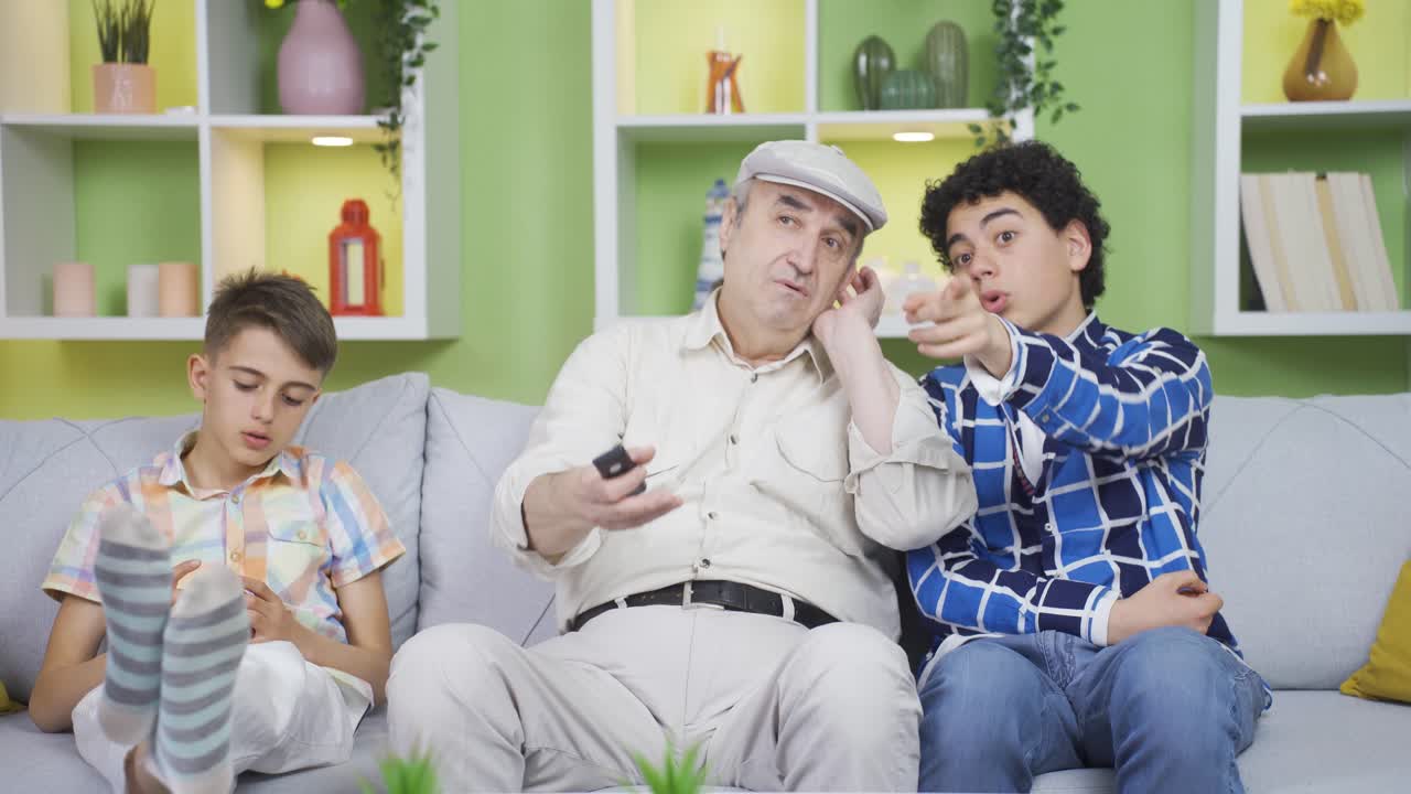 청각 장애인 할아버지는 손자가 텔레비전에서 뉴스를 알려줍니다.