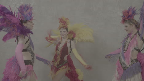 three cabaret girls dancing with colorful outfits