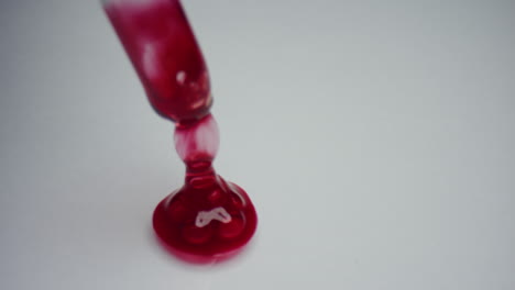 Drop-of-blood-with-pipette-on-white-background.-Researcher-stirring-blood