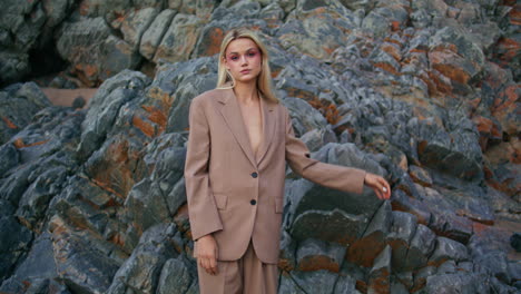 elegant woman posing outdoors on rocky beach. attractive young blonde looking